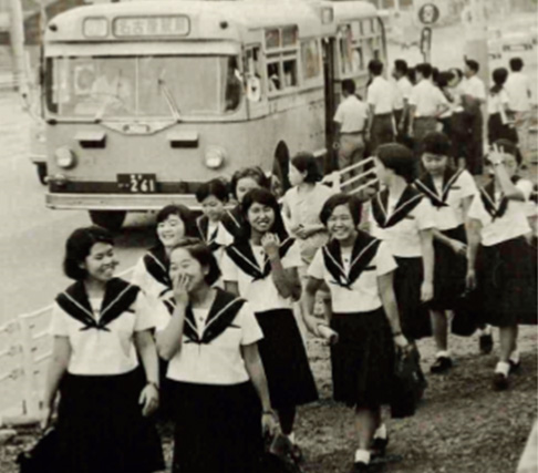 1968年（昭和43年）バス停前の登下校風景。歩道がまだ舗装されていない